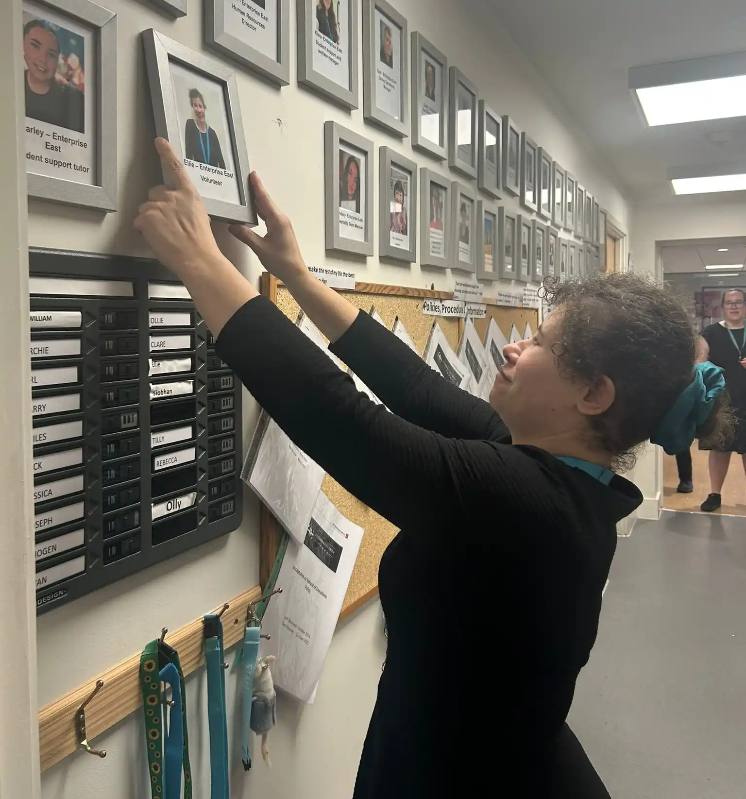 Ellie hanging her picture on the volunteer wall